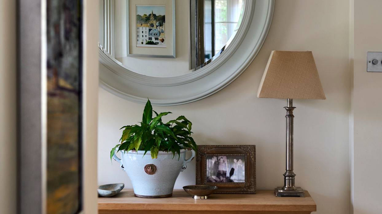 Hallway with oak console, pale blue circular mirror, Nelson Bubble lamp and accessories.