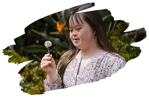 Inspired beauty: A girl with Down syndrome joyfully holds a flower, embodying the strength and joy found in diversity and unique abilities."
