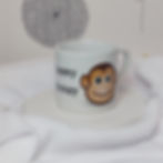 Cartoon smiling monkey face with "Cheeky Monkey" slogan in soft black text on a white mug