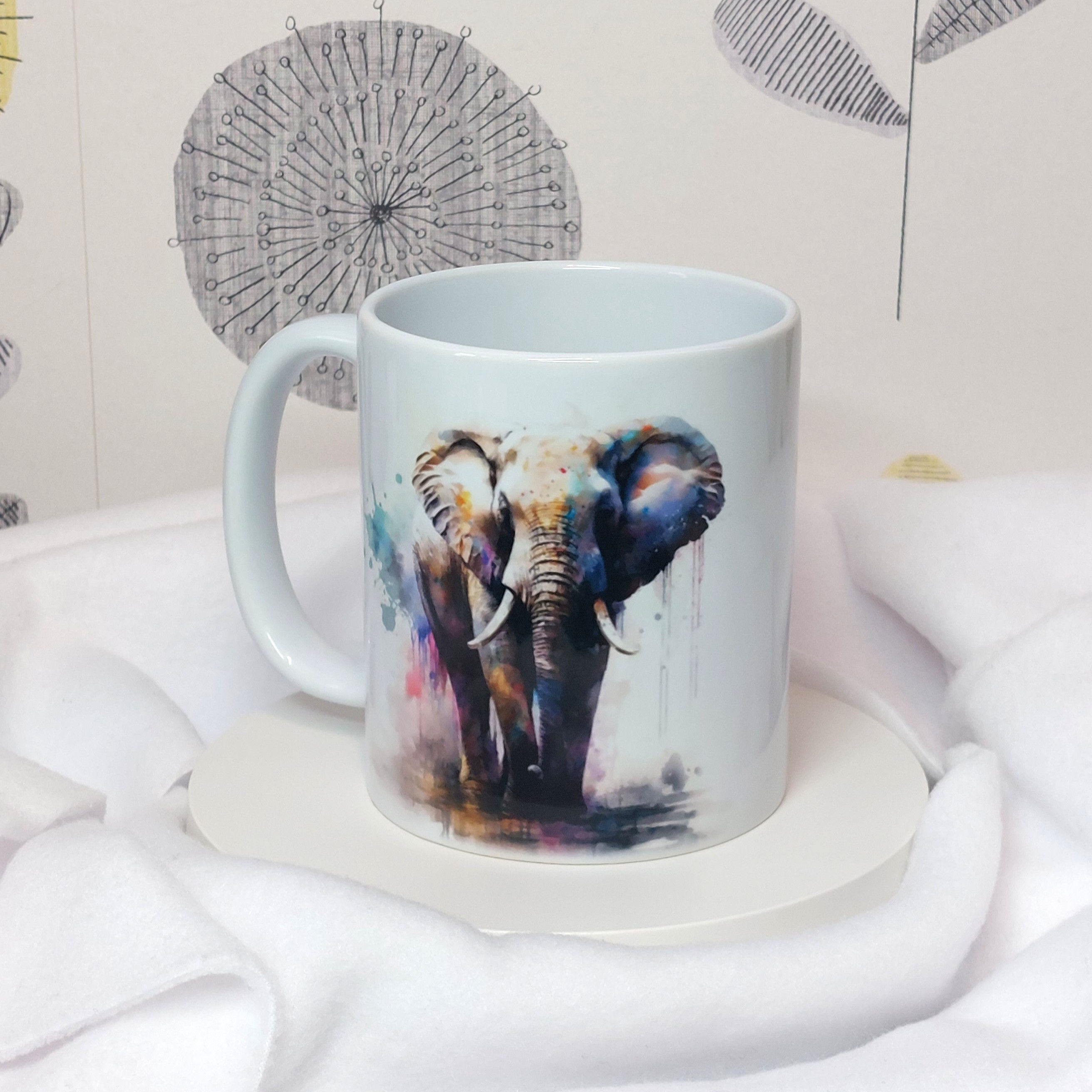Watercolour Elephant stood in a puddle with rainbow paint splashes and drips on glossy white mug