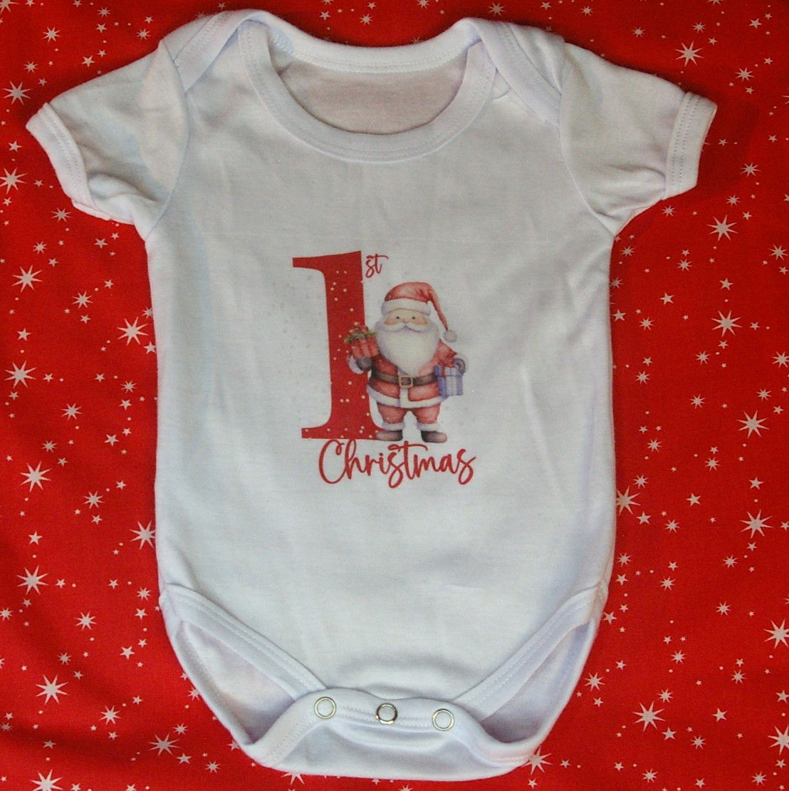 White Baby Vest with "1st Christmas" motif in red font and Santa holding presents