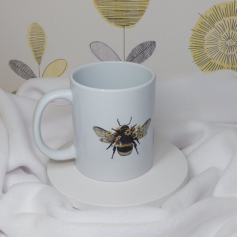 watercolour image of a Bumble Bee with flowers and the words "Bee Kind" in a soft black font on a white mug