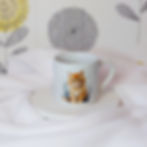 Water colour image of cute tabby ginger kitten with splatters and smokey puffs of paint on a white mug