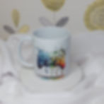 vivid rainbow coloured painting of a games controller with paint splashes and drips on a white mug