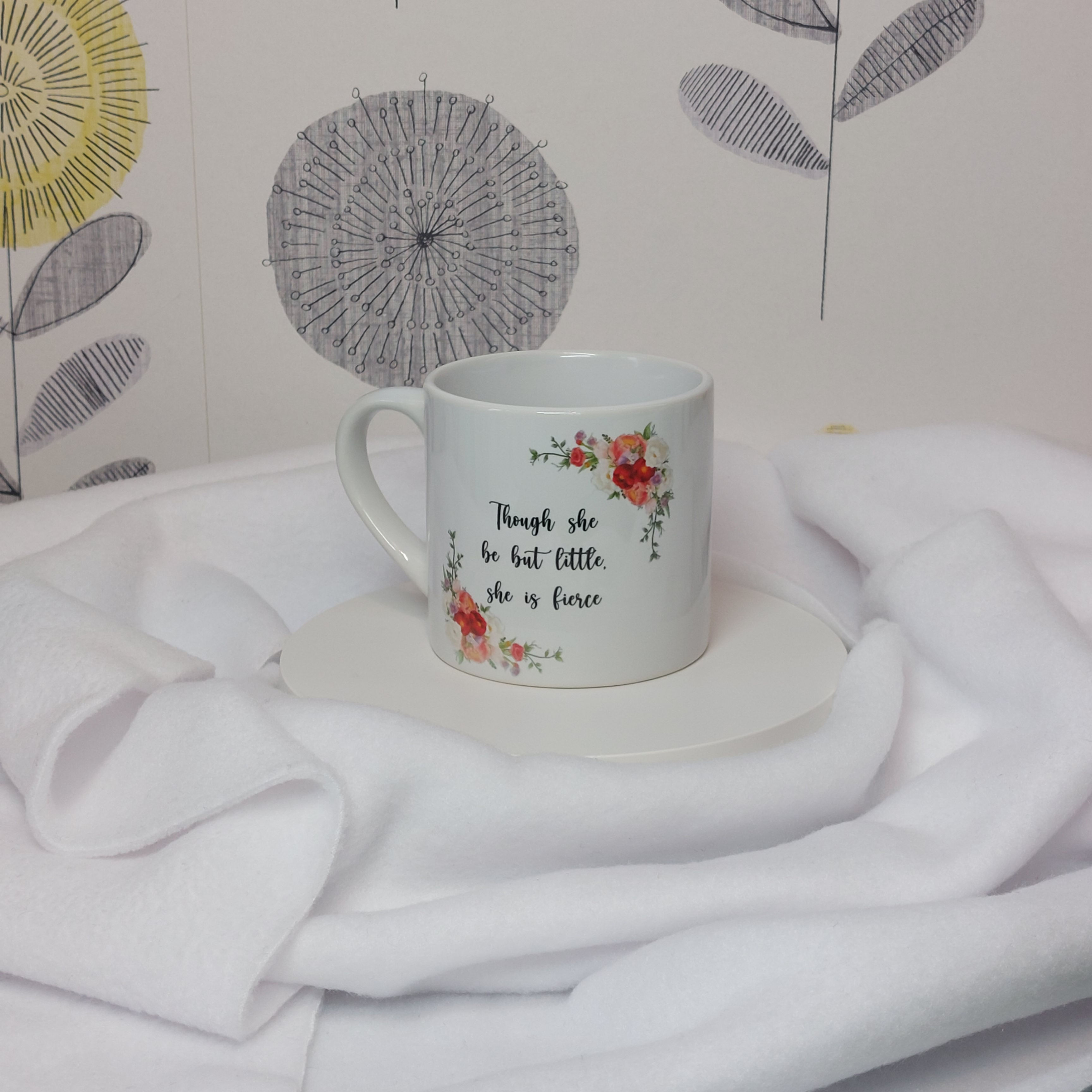 6oz Ceramic Mug Watercolour botanicals frame the slogan "Though She Be But Little, She Is Fierce" in black script
