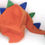 Thumbnail: An Orange funky fleece hat with attached tail and blue and green spikes