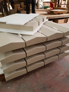 Stack of unfinished coping stones in a workshop, awaiting further processing.