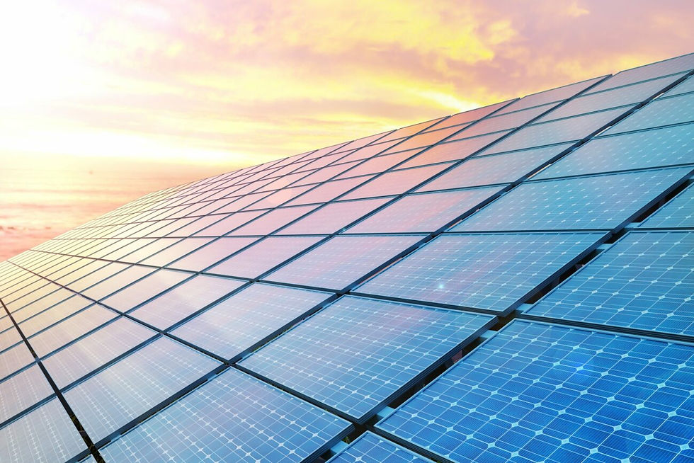 Solar panels on a roof illuminated by the warm hues of sunset