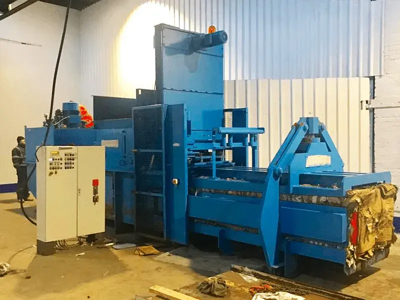 Large industrial blue baler machine in a warehouse