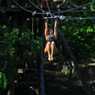 A girl on a zip line over a Cancun cenote