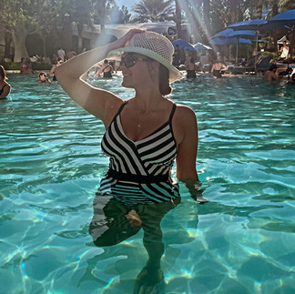 woman holding her hat in a las vegas pool