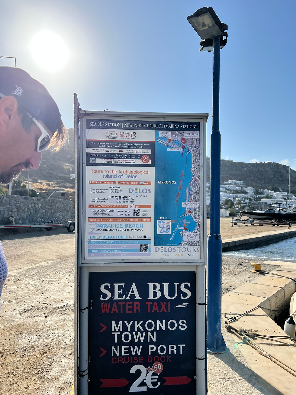 sign for Delos Tours advertising bus, port, ferry and rides in Mykonos port