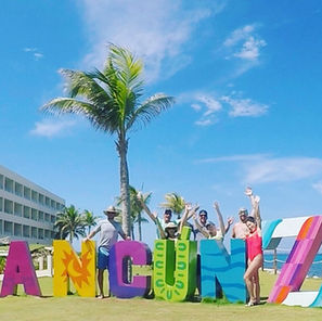 Friends in front of large letters that spell out CANCUN at Hyatt Ziva