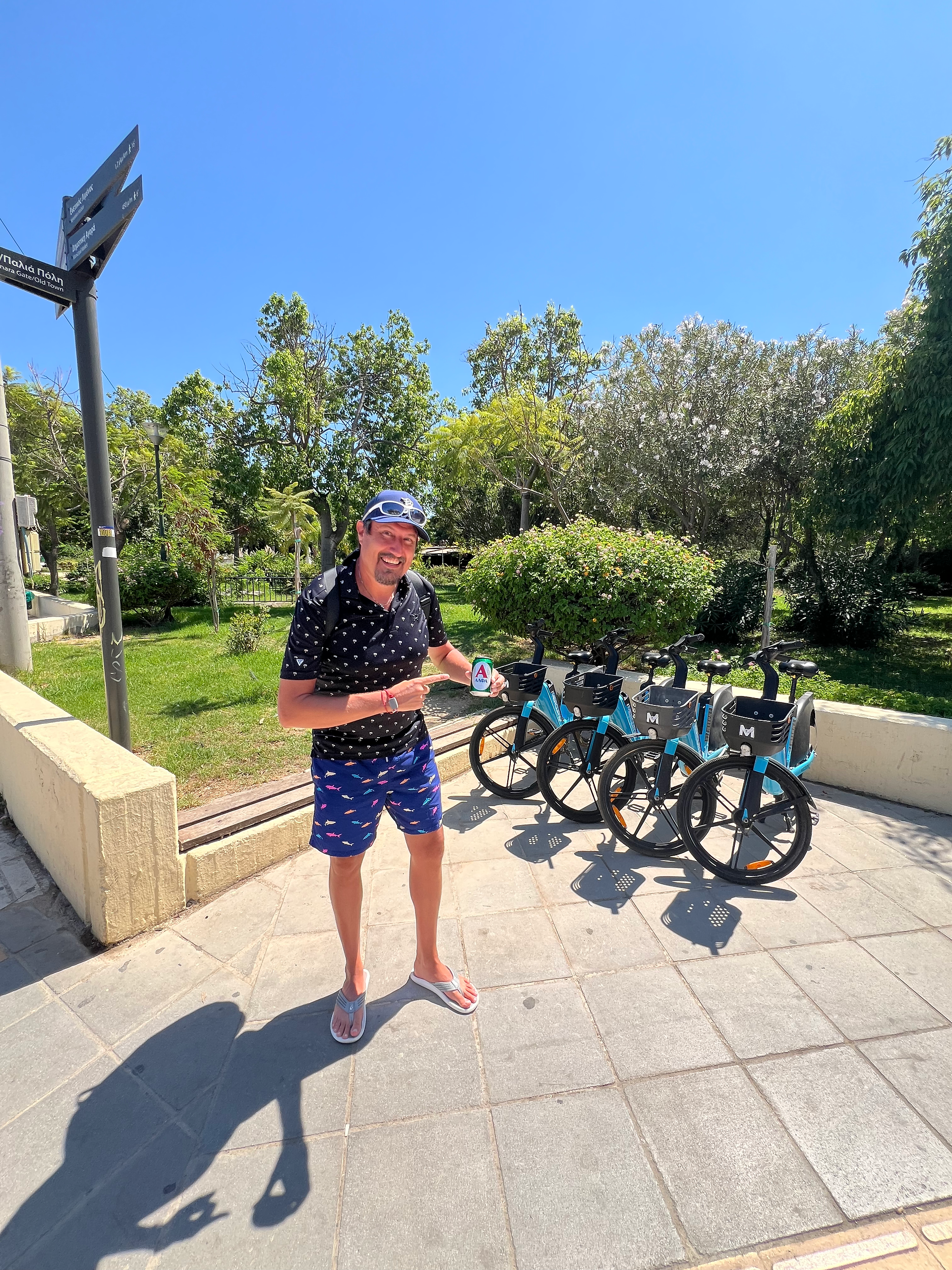 man sipping beer by a bike cart in crete