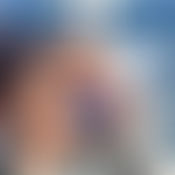 girl sitting on a boat on the ocean holding her hat looking into the sun