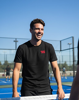 male padel player standing at the net of an outdoor padel court