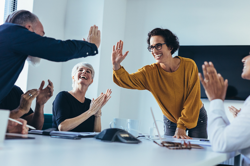 Business team celebrating success and connection after applying stress-reducing leadership strategies during a workplace culture workshop