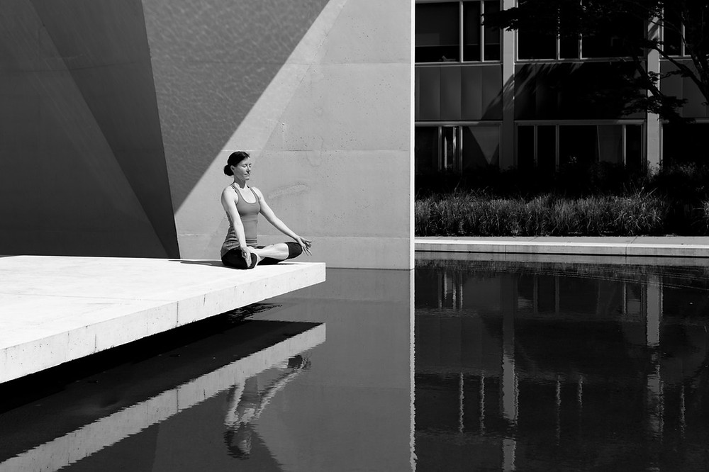 Moça meditando em posição de flor de lótus | Foto Pexels