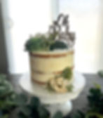 Naked cake with 'Oh Baby' topper and floral decorations