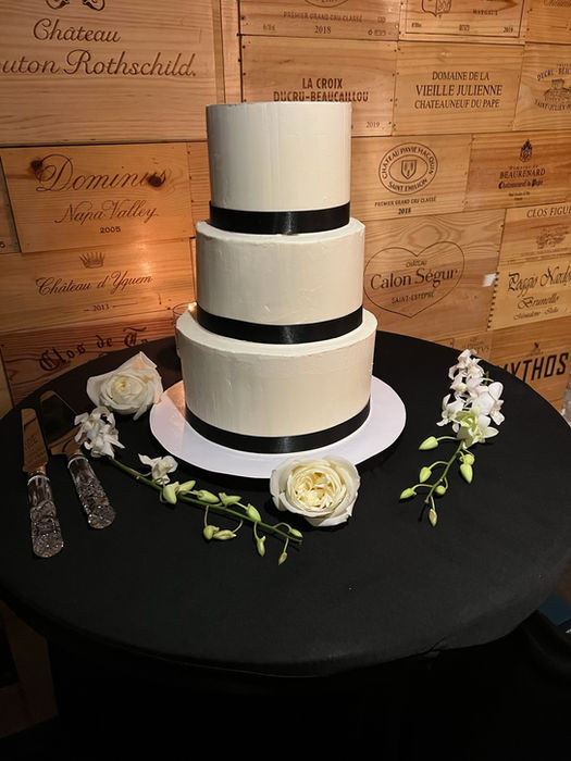 Three-tiered wedding cake with black ribbon accents