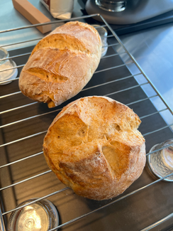 Two loaves of bread on a metal rack, fresh from the oven, Divine Dough.