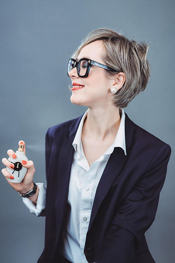 Elegant woman holding a perfume bottle, representing the boutique fragrance experience at La Parfumerie USA in Crabtree Valley Mall Raleigh