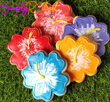 Colorful hibiscus cookies on green grass, Simply Radiant Sweets LLC treats.