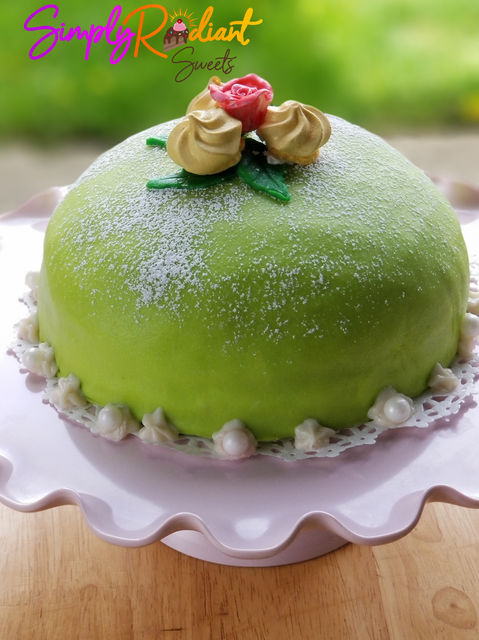 Green cake with floral details on a white plate. Simply Radiant Sweets LLC