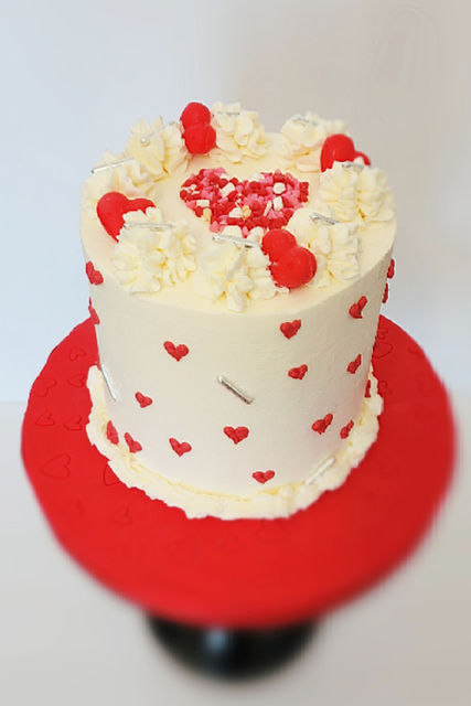 Cake decorated with hearts on a red cake stand,