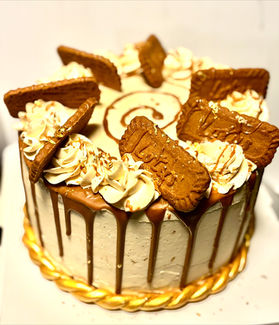 Delicious cake decorated with cookies, cream and caramel drizzle in detail