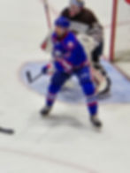 Rochester Amerks #12 Riley Fiddler Schultz is waiting on offense for puch blocking Hershey Bears goalie #35 Mitch Gibson in Friday night contest