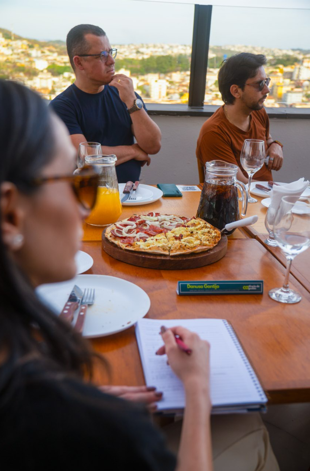 Grupo de profissionais reunidos à mesa em encontro de negócios, conversando e compartilhando ideias em ambiente descontraído