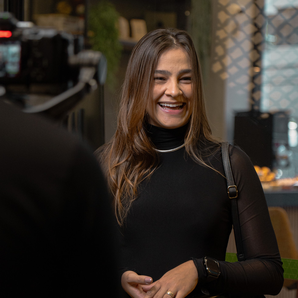 Cliente sorrindo durante gravação de depoimento em vídeo sobre experiência com a Conexões de Negócio em ambiente corporativo