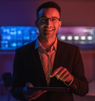 happy-man-glasses-working-with-tablet-dark-room.jpg