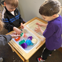 Therapist sitting at a table with a child.