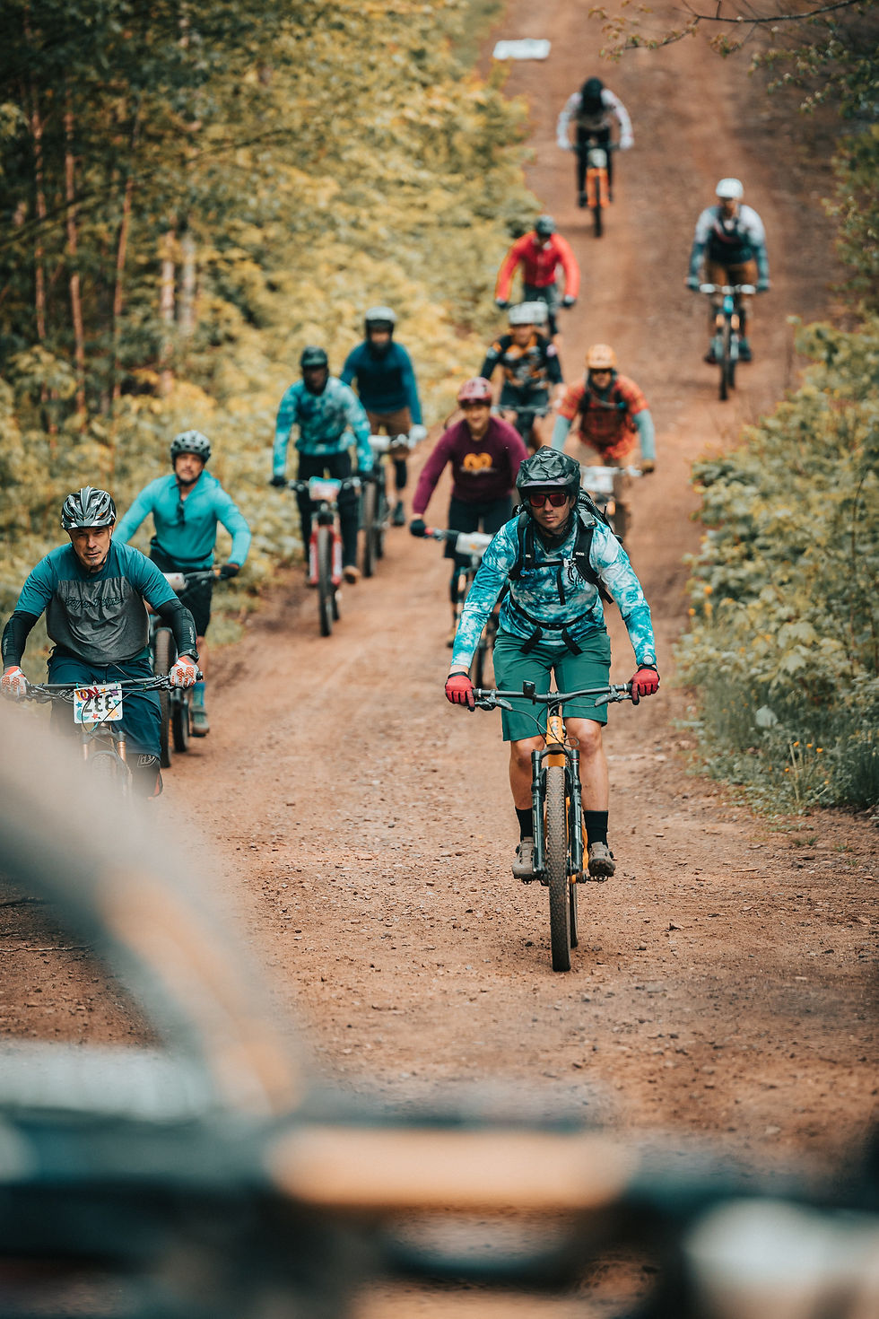 Group of mountain bikers riding down hill in Copper Harbor Michigan, East Bluff Bike Park