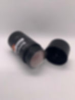 Stick noir Batana Plus, ouvert avec son capuchon posé à côté.