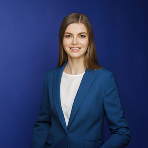 Confident young woman in a blue suit – clean professional CV portrait with royal blue background.