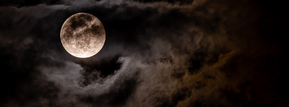 Full moon obscured by dark night clouds