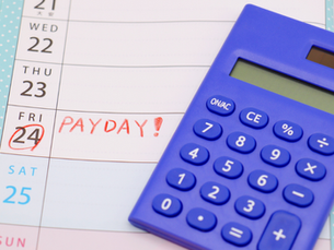 Blue calculator on a calendar page with "PAYDAY!" written in red on Friday the 24th, conveying excitement. Background has a blue dotted pattern.