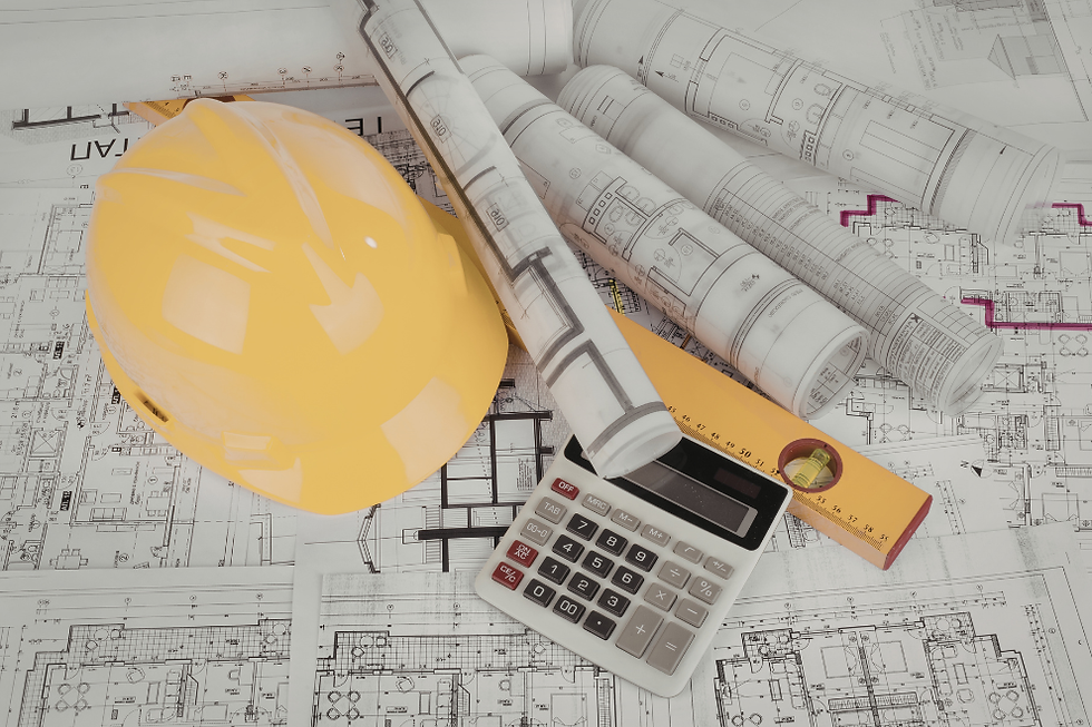 Yellow hard hat, calculator, level, and rolled blueprints on architectural plans. Tools of architecture and construction.