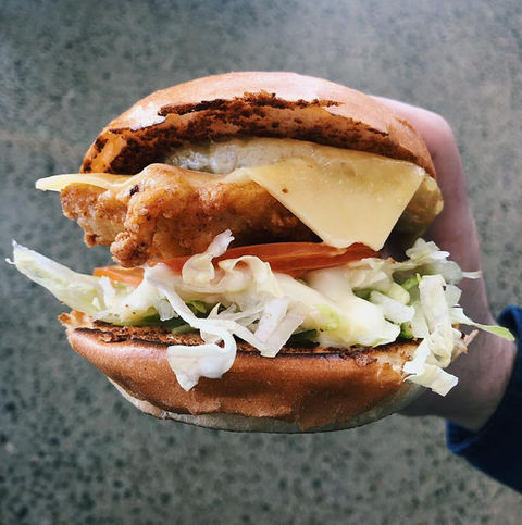 Aloha Krunchy Chicken Burger held in one hand