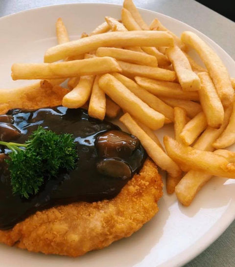 Schnitzel & Chips with Mushroom Gravy poured on top of the schnitzel
