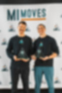 Kyler and Aaron smiling and holding their certifications to be a personal trainer