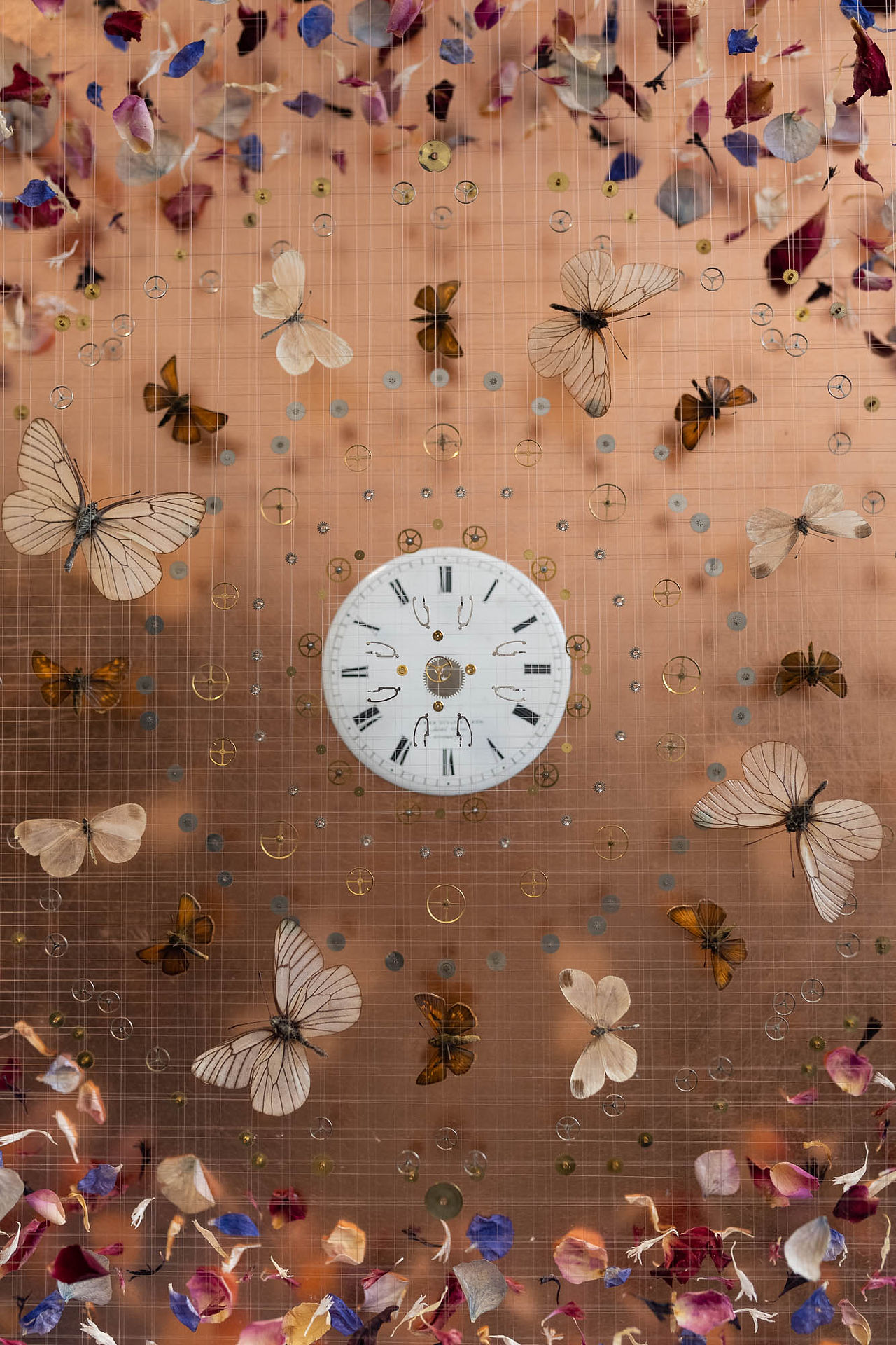 Artwork with watch and clock parts, butterflies and dried petals on copper