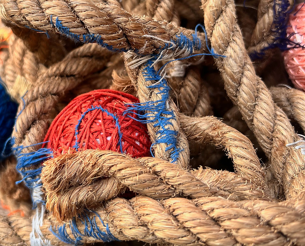 Knots of rope and coloured balls stitched together with colourful embroidery thread