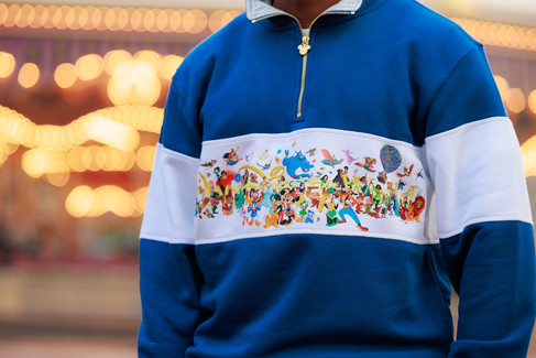 Close up of a blue and white quarter-zip pullover featuring various Disney characters.