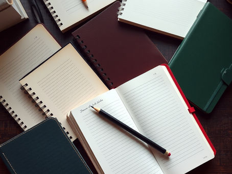 Several blank notebooks scattered on a desktop.