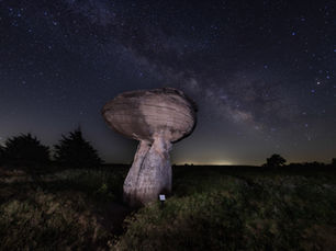 A rock formation at Mushroom Rock State Park in Kansas stands tall in front of the Milkyway.