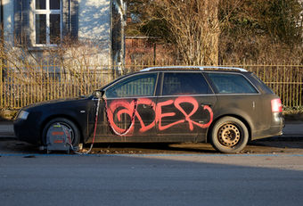 Seitenansicht eines stillgelegten Autos mit Radkralle auf einem Parkplatz. Die Aufnahme stammt aus einer wöchentlichen fotografischen Langzeitdokumentation.